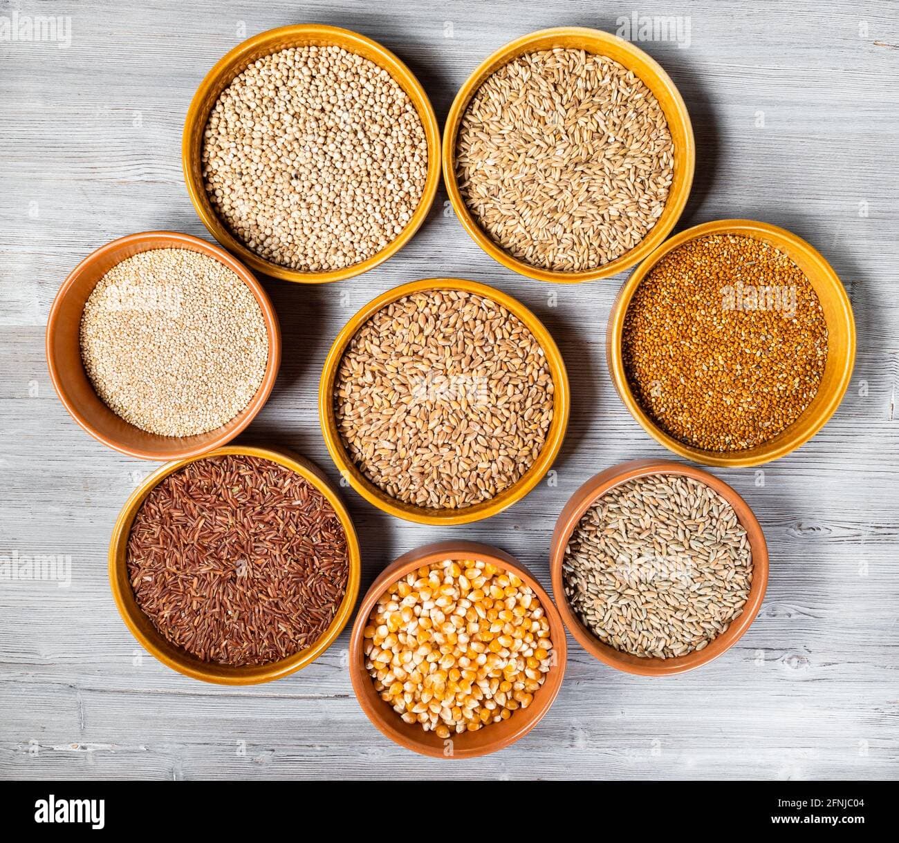 Assorted whole grains in bowls — rice, wheat, millet, oats